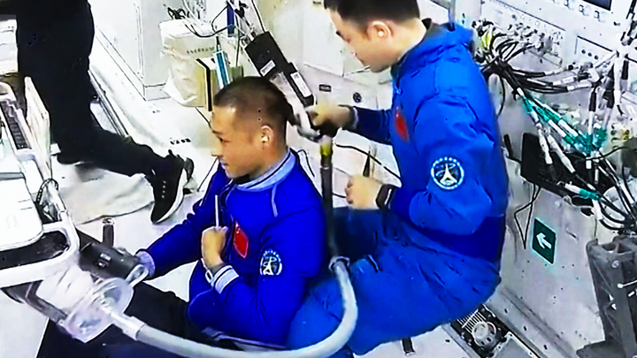 Các phi hành gia Trung Quốc tiến hành cắt tóc, gội đầu bằng các thiết bị hết sức đặc biệt trên Trạm vũ trụ Thiên Cung (Tiangong). (Ảnh: CCTV)