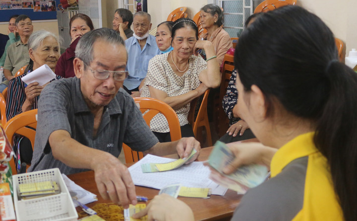 Chi trả lương hưu theo mức hưởng mới tại Tổ dân phố 15 (phường Năm Lý, TP Đồng Hới, Quảng Bình). (Ảnh: Huy Hương)