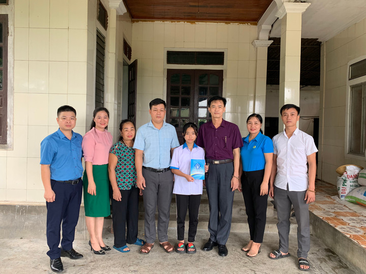Đại diện lãnh đạo chi bộ, lãnh đạo BHXH huyện Quỳnh Lưu và đại diện lãnh đạo xã Quỳnh Đôi tặng quà cho em Hồ Thị Ngọc Hân