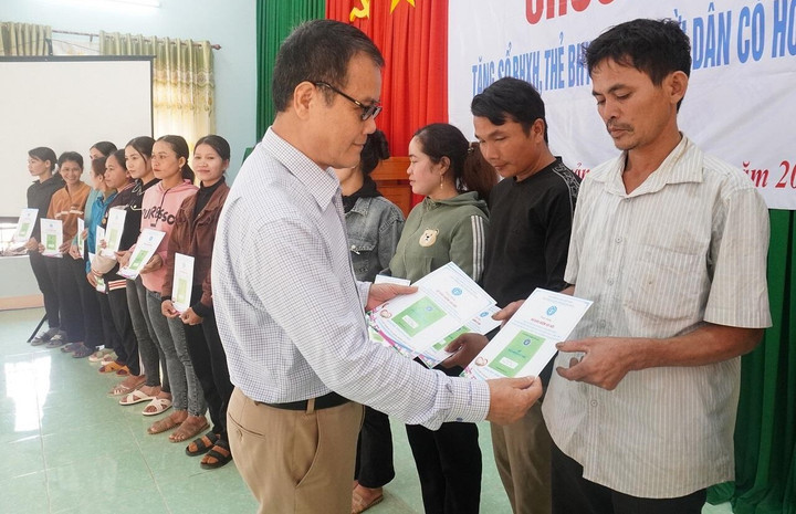 Phó Giám đốc Bảo hiểm xã hội tỉnh Quảng Ngãi Trương Quang Hùng trao sổ BHXH cho người dân có hoàn cảnh khó khăn ở xã Long Sơn.