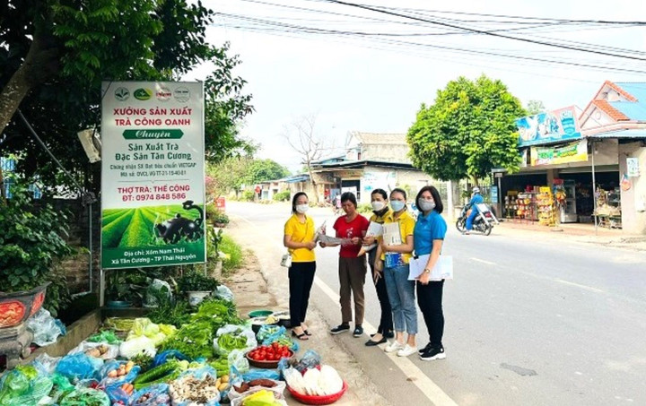 Cán bộ BHXH tỉnh, Bưu điện thành phố Thái Nguyên đi tuyên truyền lưu động tại các khu chợ dân sinh. (Ảnh: T. Huệ)