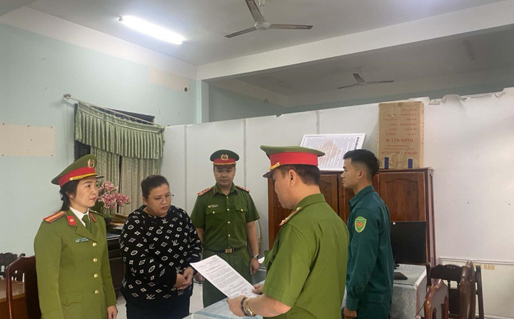 Lực lượng chức năng đọc quyết định khởi tố Lê Thị Ngân Hà. (Ảnh: C.A)