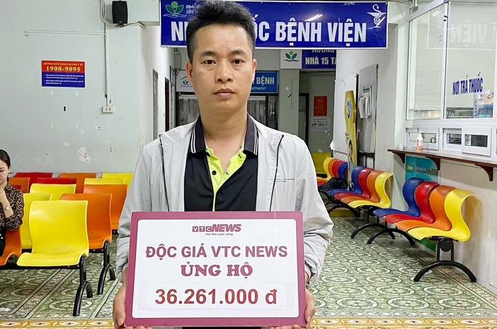 Đại diện gia đình bé Quang đón nhận tấm lòng của bạn đọc.