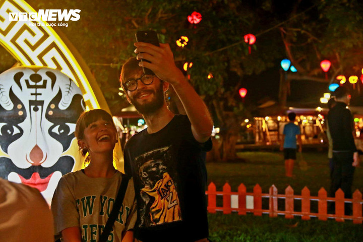 Hai du khách nước ngoài ghi lại khoảnh khoắc chuẩn bị đón đêm Giao thừa tại phố cổ Hội An.