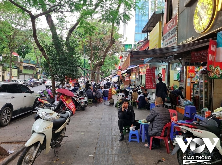 Trật tự vỉa hè một số khu vực trên tuyến phố Lý Thường Kiệt, Đinh Tiên Hoàng... hiện chưa được đảm bảo. Bàn ghế và xe cộ chắn hết lối đi của người đi bộ, hoặc khoảng trống còn lại rộng chưa đến 1m. (Ảnh: Minh Hiếu)