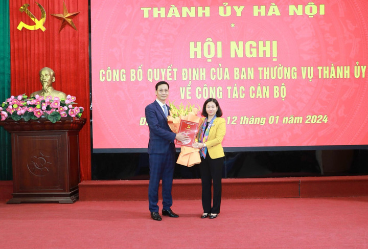 Phó Bí thư Thường trực Thành ủy Nguyễn Thị Tuyến trao quyết định, tặng hoa chúc mừng ông Lê Thanh Nam.