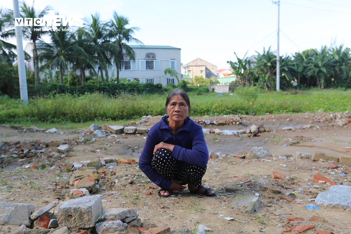 Bà Phạm Thị Bảy ngồi trên nền nhà bị hai con đập phá. (Ảnh: Trọng Tùng)