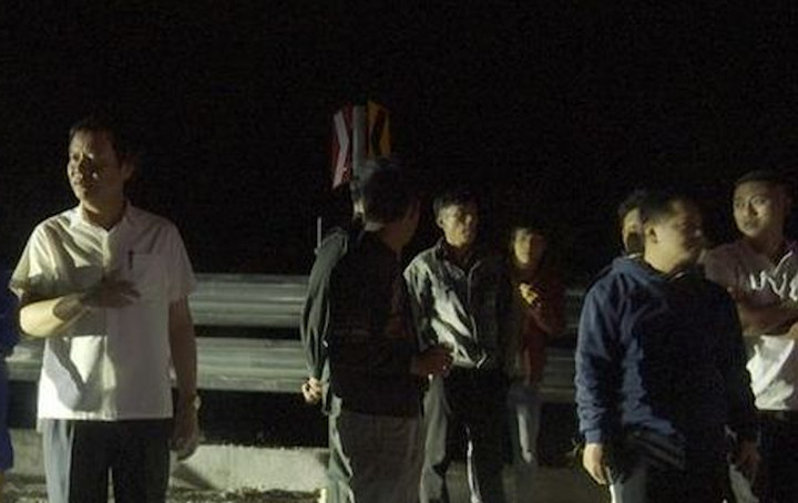 Trong đêm 13/1, ông Thái Ngọc Châu (áo trắng) có mặt tại hiện trường chỉ đạo lực lượng thu hồi số gạo bị lấy từ xe gặp nạn. (Ảnh: A.C)