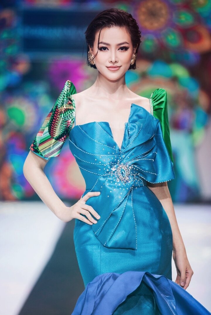 Hoa hậu Phương Khánh khoe nhan sắc mặn mà trên sàn diễn. Cô diện trang phục có gam màu xanh tươi sáng của nhà thiết kế Phillippines Norman Malagueno Acuba.