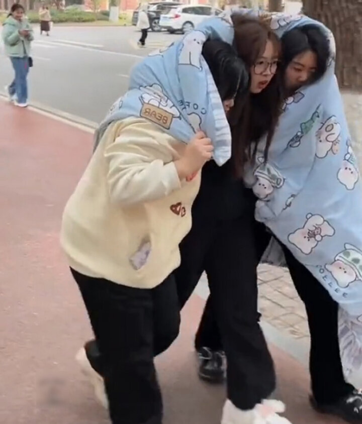 Ba cô nàng con trẻ teo ro công cộng nhau quấn một tấm chăn - thời trang và năng động đến lớp thân thuộc những thời nay. (Ảnh: Titkok/@khonggiannhocuatoi)