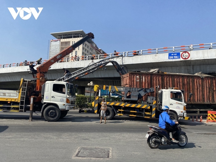 Hiện trường vụ xe đầu kéo chở container va chạm, kéo gãy đổ khung sắt gắn các biển chỉ dẫn giao thông bắc ngang quốc lộ 1A. (Ảnh: A.V)