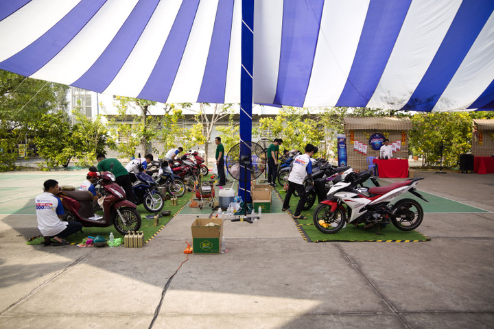 Đội ngũ kỹ thuật tận tình kiểm tra và thay nhớt cho các công nhân tham gia ngày hội.