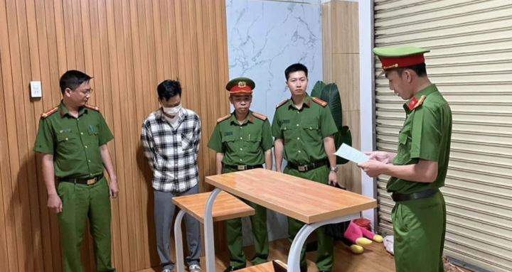 Lực lượng công an đọc lệnh bắt giữ Trần Quốc Huy. Ảnh: CACC