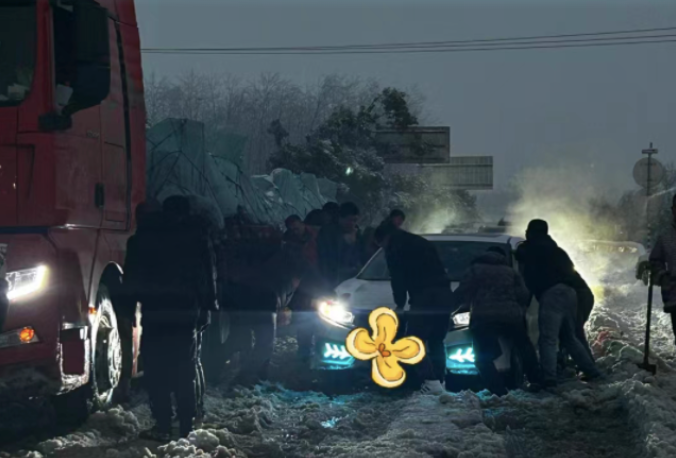 Người đi đường hỗ trợ chiếc xe bị kẹt trên mặt đường phủ đầy tuyết. (Ảnh: The Paper)