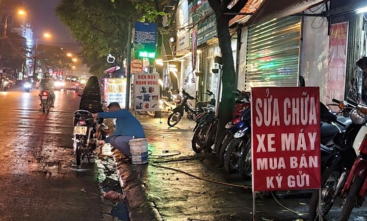 Chiếm dụng lòng đường, vỉa hè rửa xe máy. (Ảnh: VOV)