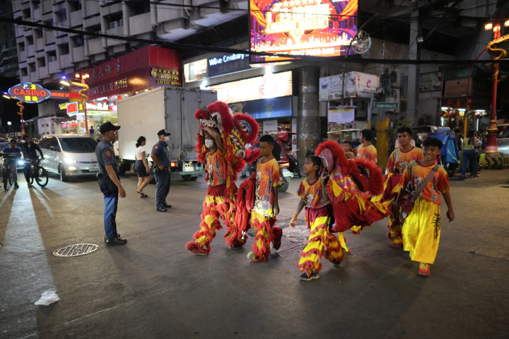 Những thanh thiếu niên biểu diễn sư tử băng qua một con đường quận Binondo, được cho là khu phố Tàu lâu đời nhất trên thế giới, ở thủ đô Manila, Philippines.