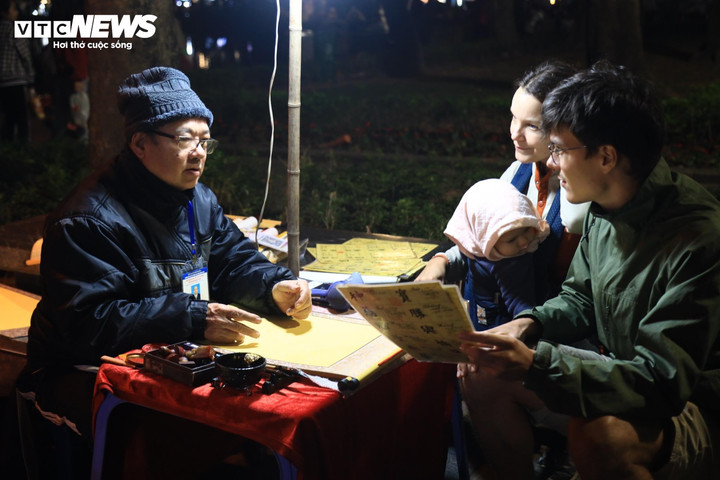 Những gian hàng xin chữ, trước và sau khu vực cổng đền Ngọc Sơn (Hà Nội), thu hút khách nước ngoài.