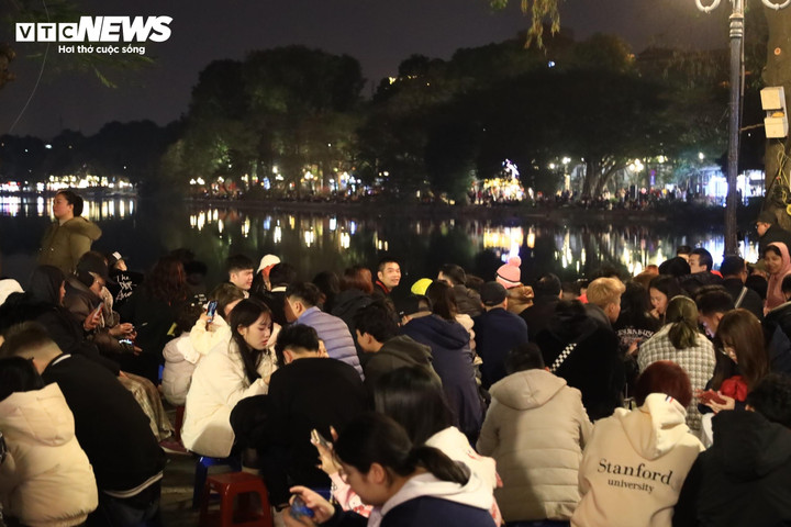 Đông kín người dân ngồi ghế dọc bờ hồ Hoàn Kiếm, chờ đợi khoảnh khắc giao thừa.