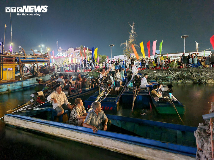 Người dân ngồi trên thuyền theo dõi màn bắn pháo hoa.