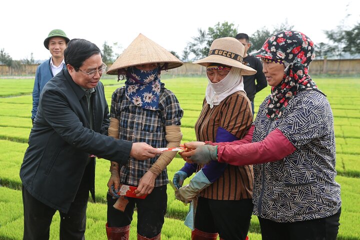 Thủ tướng lì xì đầu năm cho nông dân. (Ảnh: VGP/Nhật Bắc)