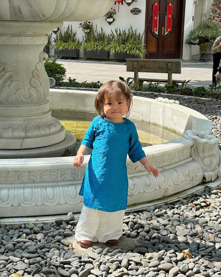 Áo dài mùng 3 Tết của Pam được thiết kế theo phom suông và cổ tròn đặc trưng. Điểm ấn tượng nhất của "outfit" này là tông màu xanh dương bắt mắt.