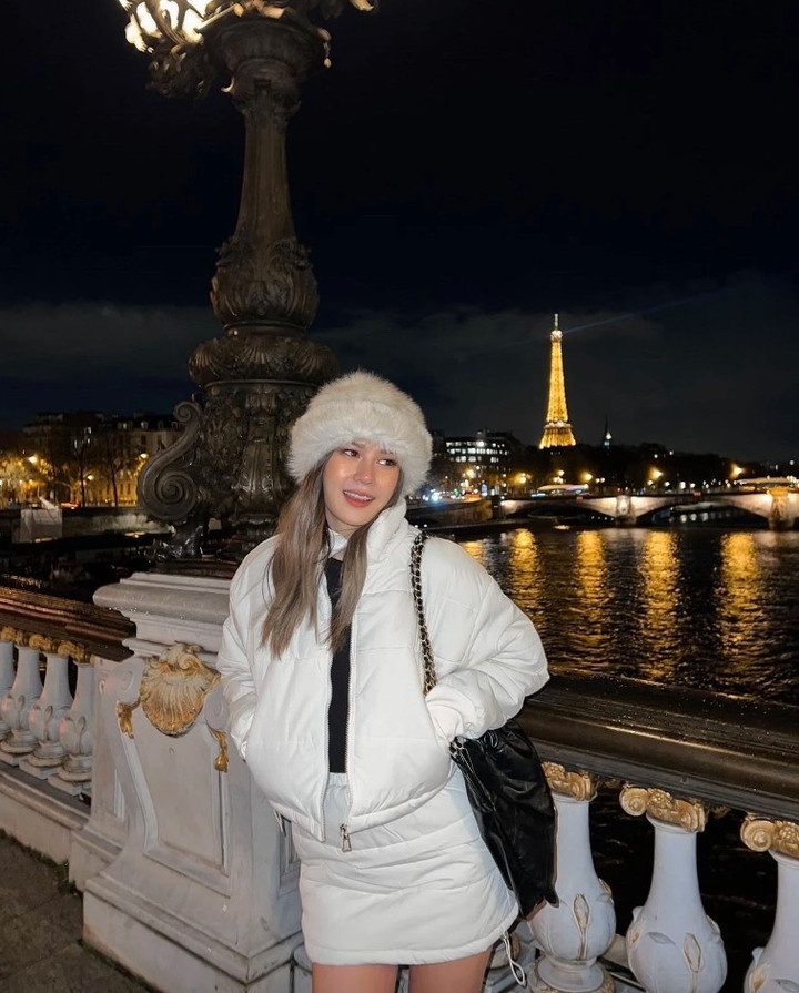 Set đồ gồm áo phao sáng màu và chân váy, kết hợp cùng mũ lông dày dặn khiến cô nàng vẫn quyến rũ giữa mùa đông.