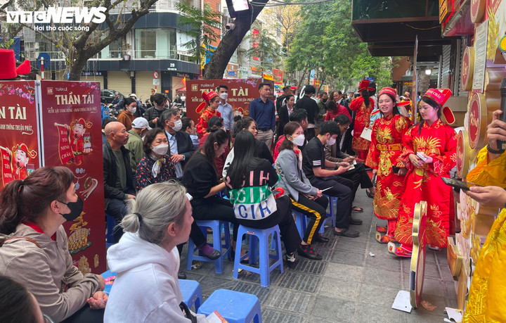 Nhân viên tiệm vàng mặc trang phục Thần Tài liên tục phục vụ nước uống, tặng bật lửa lấy may đầu năm cho khách đến giao dịch.