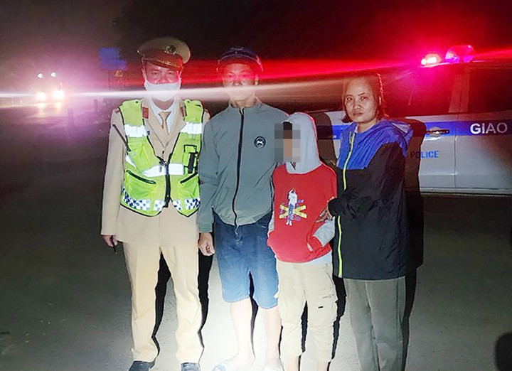 Lực lượng CSGT bàn giao cháu bé bị lạc cho gia đình.