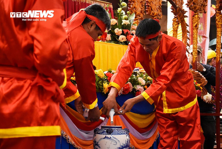 Máu gà trống được hòa vào bình rượu lớn.