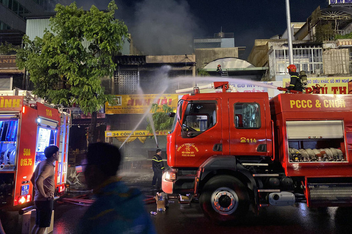 Lực lượng chữa cháy nỗ lực dập lửa. (Ảnh: Như Sỹ)
