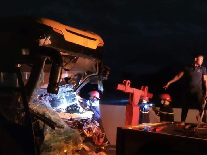 Lực lượng chức năng đưa thi thể tài xế xe khách và phụ xe ra ngoài (Ảnh: LK)