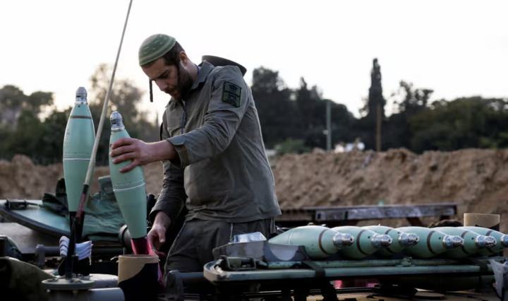 Một binh sĩ Israel chuẩn bị đạn súng cối trước cuộc tấn công vào Gaza. (Ảnh: Reuters)