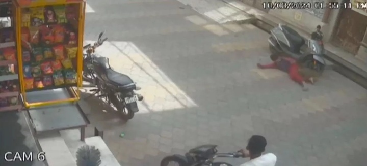 Cậu bé ngã xuống đường sau khi bị khỉ cắn vào chân. (Ảnh: @mirrornow/Facebook)