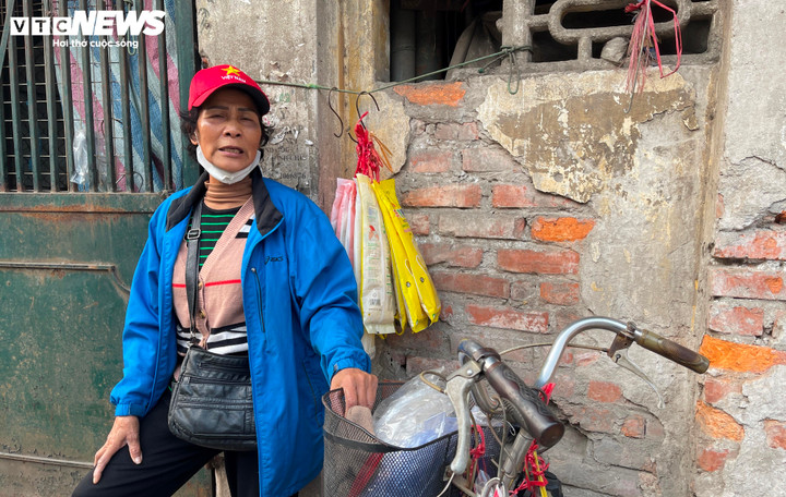 Bà Dung ra tận cổng chợ, phía ngoài cách cửa sắt khóa trái để đón khách.