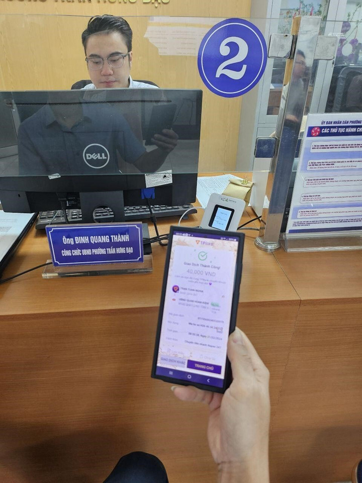 Cán bộ UBND phường Trần Hưng Đạo, Quận Hoàn Kiếm, Hà Nội hướng dẫn người dân sử dụng tiện ích thanh toán không tiền mặt qua cổng thanh toán của PayTech.