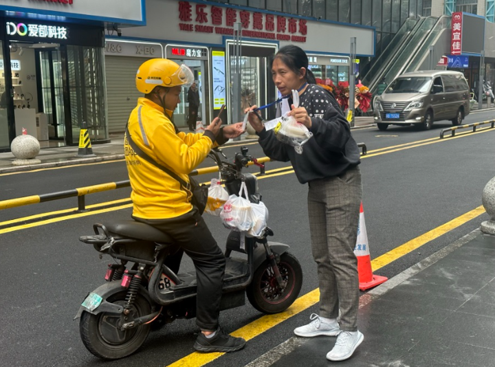 Một shipper đang thanh toán phí giao hàng cho một người nhận hộ đồ ăn ở thành phố Thâm Quyến, Trung Quốc. (Ảnh: SPH Media)