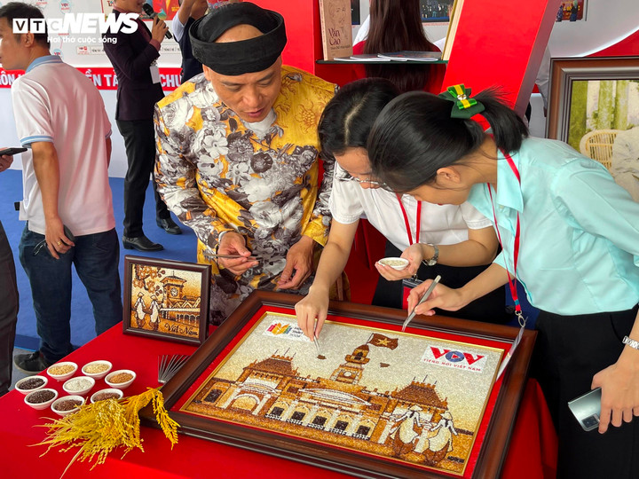 Tại gian hàng, hoạt động ghép tranh gạo logo VOV với nghệ nhân thu hút sự chú ý của nhiều người có mặt. Các PV, BTV của Đài Tiếng nói Việt Nam hào hứng khi được góp một phần công sức tạo nên bức tranh.