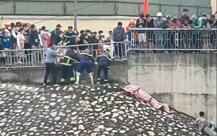 Lực lượng chức năng đưa thi thể lên bờ.