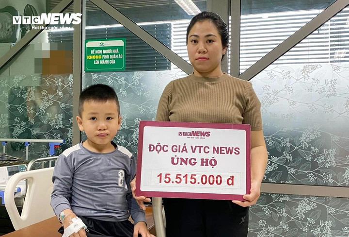 Chị Tuyết nhận bảng tượng trưng số tiền 15.515.000 đồng bạn đọc ủng hộ bé Hiếu.