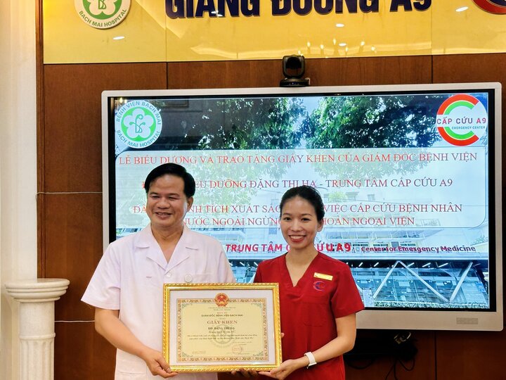 Giám đốc Bệnh viện Bạch Mai Đào Xuân Cơ tặng giấy khen cho nữ điều dưỡng.