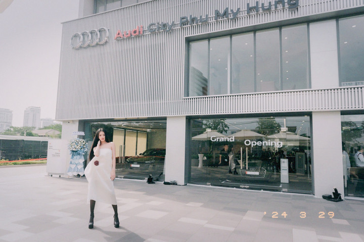 Á hậu 1 Miss Grand 2023 Bùi Khánh Linh thả dáng cá tính trong trang phục váy trắng và bốt cao cổ đen.