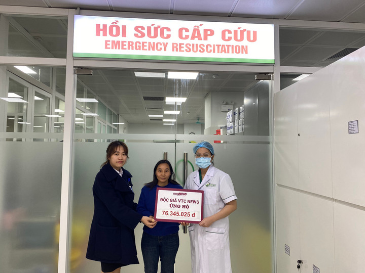 Chị Đặng Thị Thanh nhận tiền ủng hộ của độc giả trước sự chứng kiến của đại diện Bệnh viện Hữu nghị Việt Đức.