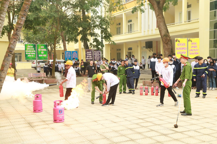 Học sinh được hướng dẫn sử dụng bình cứu hoả để dập lửa.