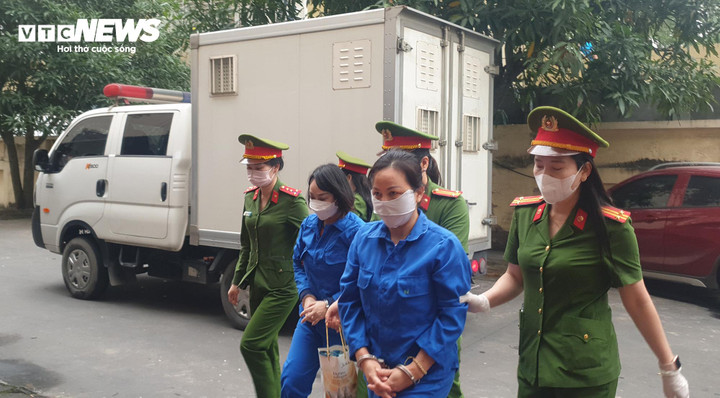 Bị cáo Nguyễn Thị Ngọc Anh (bên trái), vợ "trùm buôn bán hoá đơn" Trương Xuân Đước được áp giải đến toà.