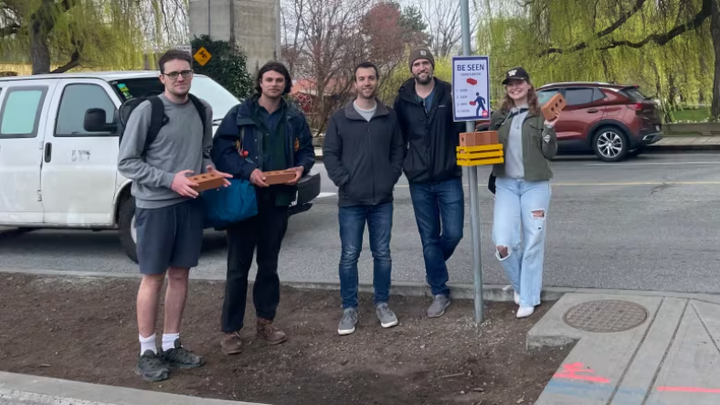 Các tình nguyện viên của Vision Zero Vancouver cầm những viên gạch xốp ở giao lộ lối vào Island Granville. (Ảnh: CBC)