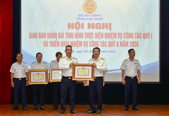 Tổng cục trưởng Mai Xuân Thành trao Bằng khen của Bộ trưởng Bộ Tài chính cho Cục Thuế TP Hà Nội vì đã có thành tích xuất sắc trong công tác quản lý, sử dụng HĐĐT đối với hoạt động kinh doanh, bán lẻ xăng dầu.