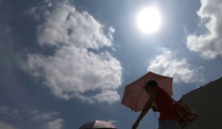 Người dân cầm ô đi bộ dưới nắng nóng ở Singapore. (Ảnh: Today)
