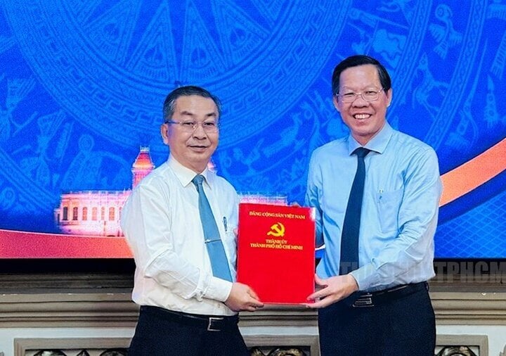 Chủ tịch UBND TP.HCM Phan Văn Mãi (phải) trao quyết định cho ông Võ Ngọc Quốc Thuận. (Ảnh: Thành ủy TP.HCM)