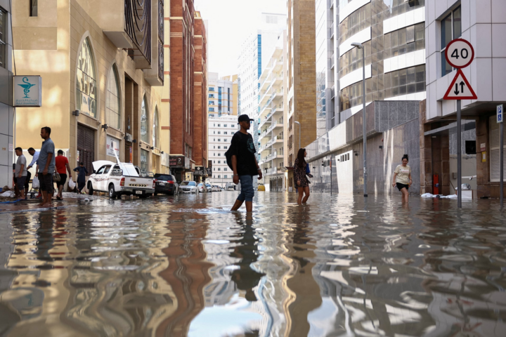 Thành phố sa mạc không được thiết kế để thoát nước trong những trận mưa lớn bất thường; trong ảnh, người dân đang đi lại trên đường phố Dubai hôm 17/4. (Ảnh: Reuters)