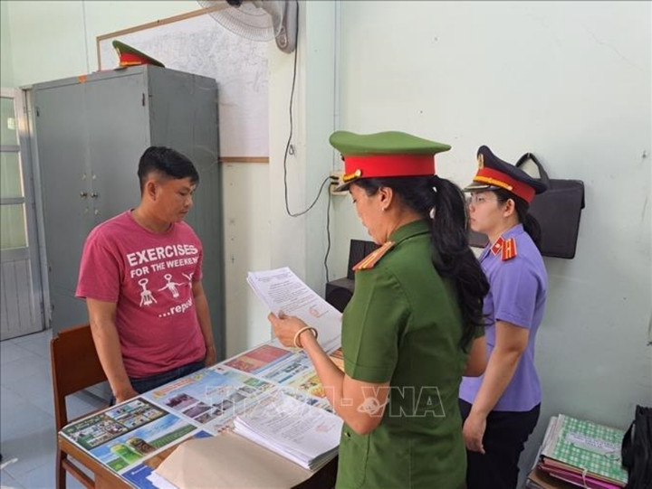 Lực lượng chức năng tống đạt các Quyết định và Lệnh bắt tạm giam đối tượng Phan Thành Được (trái, áo đỏ).